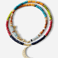 Colorful beaded necklace with a gold crescent moon pendant on a white background