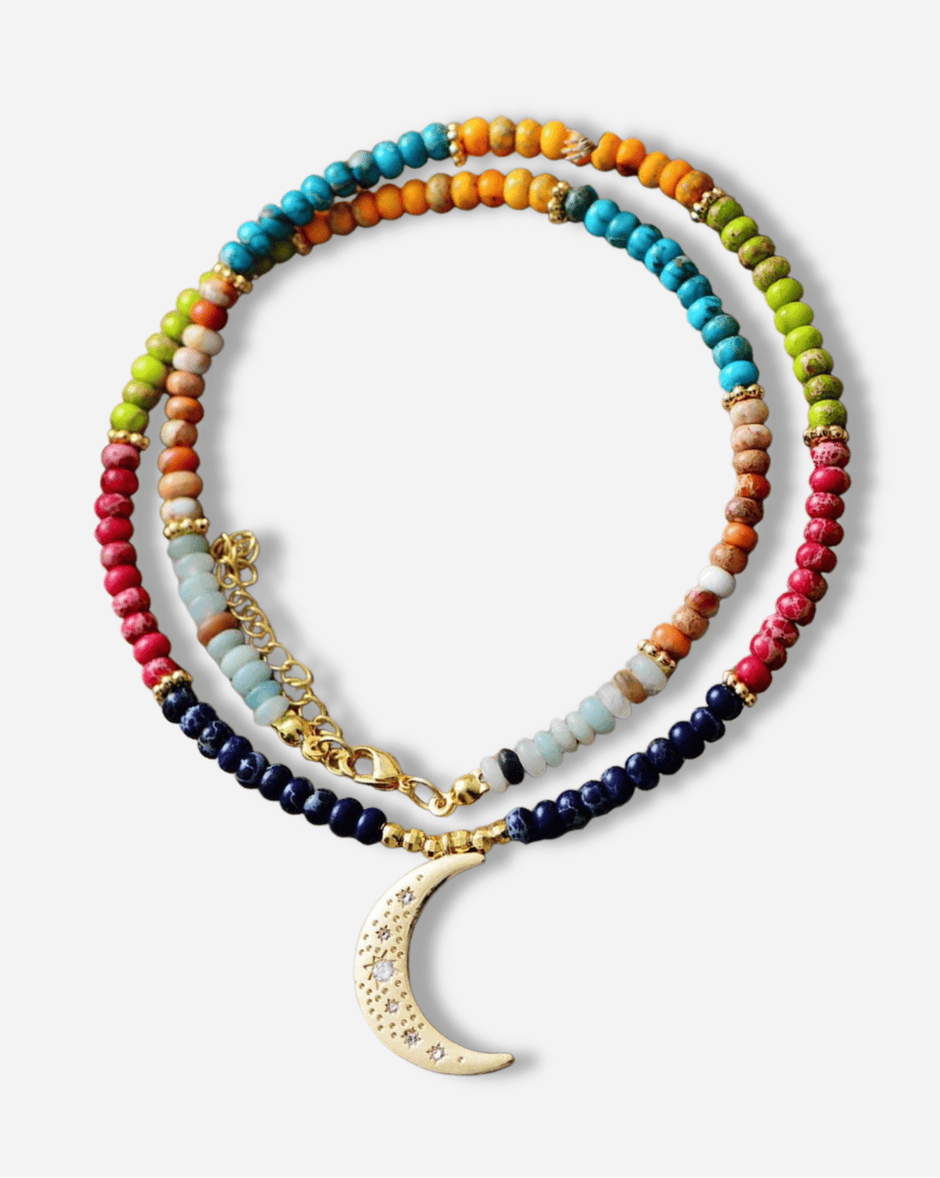 Colorful beaded necklace with a gold crescent moon pendant on a white background