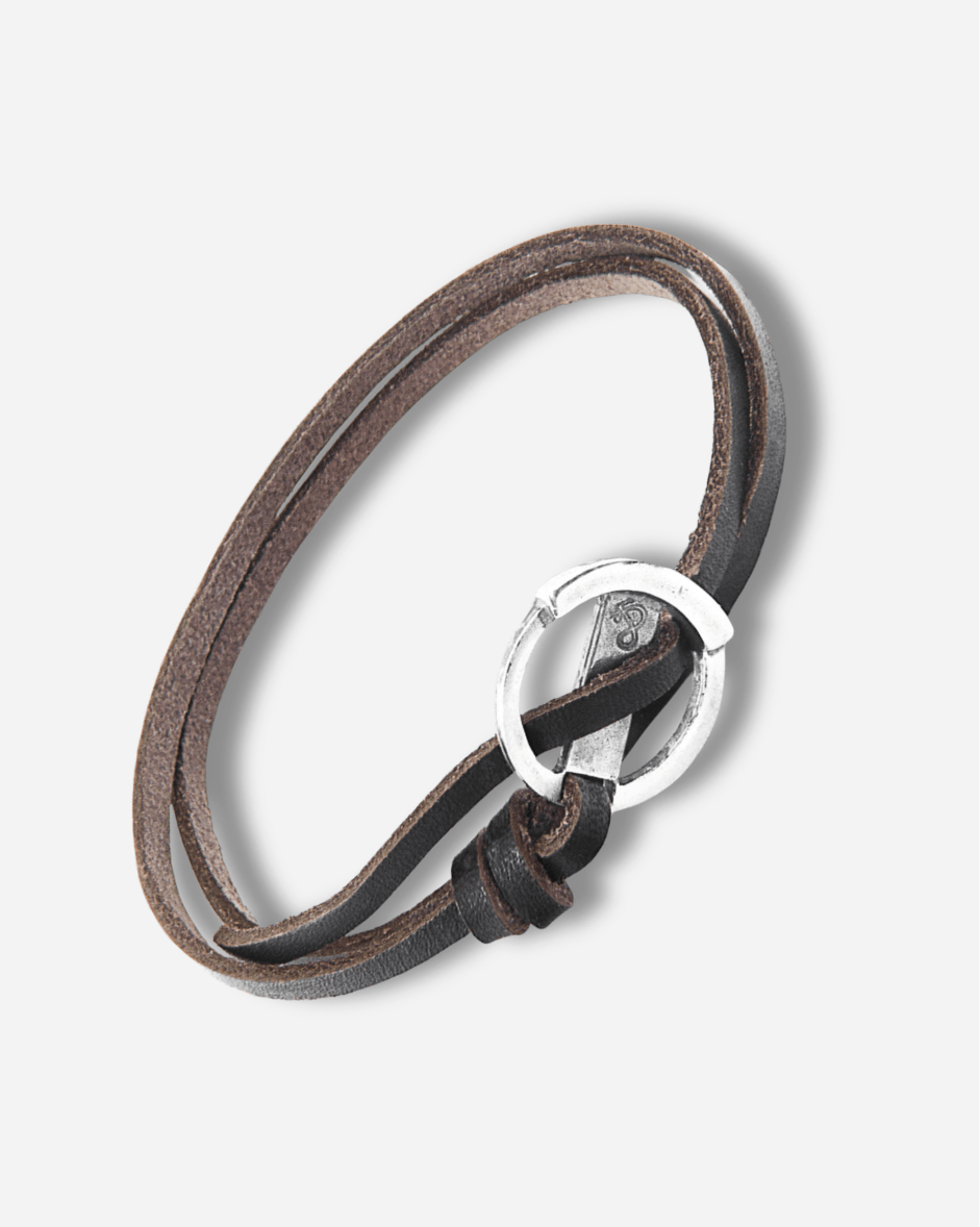 Brown leather bracelet with a silver clasp on a light gray background