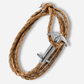 Brown braided leather bracelet with silver anchor charm on a white background