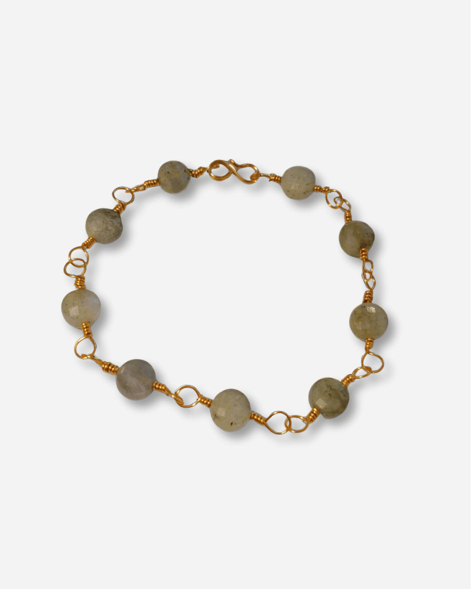 Bracelet with gold chain and green beads on a white background