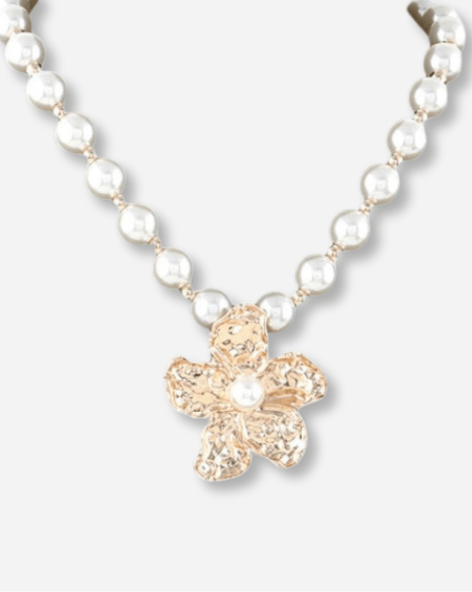 Pearl necklace with a gold cross pendant on a white background