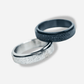 Two rings, one silver and one blue, on a light gray background