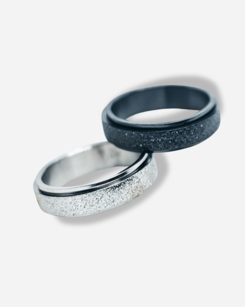 Two rings, one silver and one blue, on a light gray background