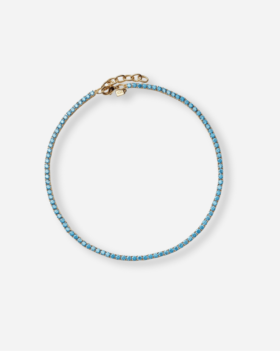 Blue beaded bracelet with gold clasp on a white background