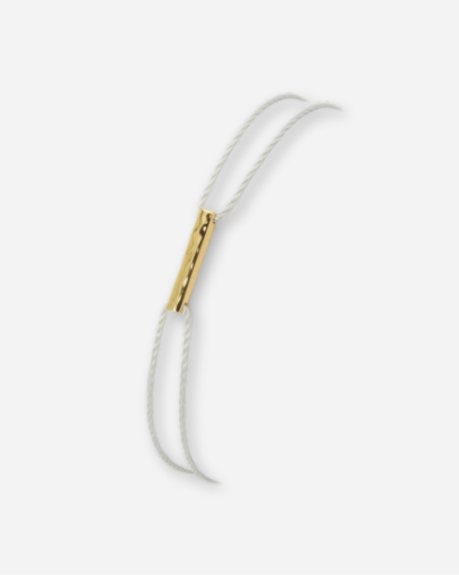 White bracelet with gold clasp on a white background
