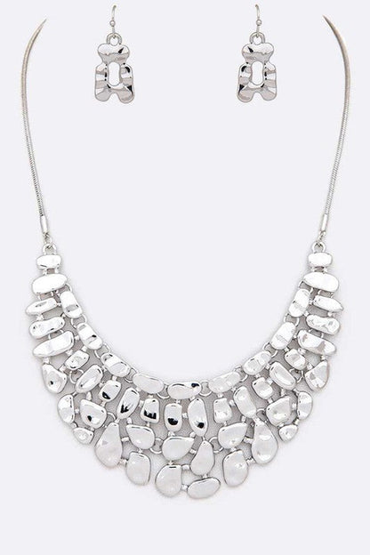 Silver necklace and earrings set on a white background