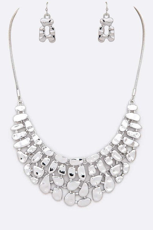 Silver necklace and earrings set on a white background