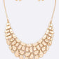 Gold necklace and earrings set on a white background