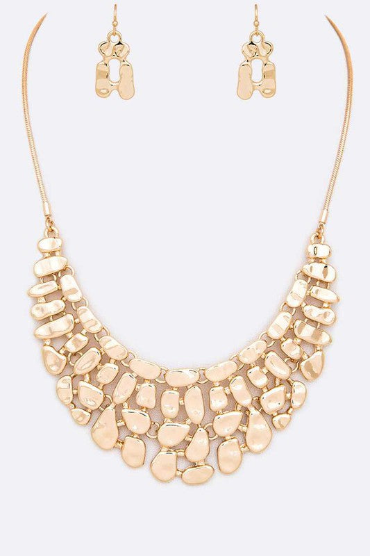 Gold necklace and earrings set on a white background