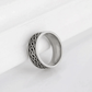 Silver ring with intricate design on a white background