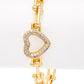 Gold bracelet with a heart-shaped clasp on a white background