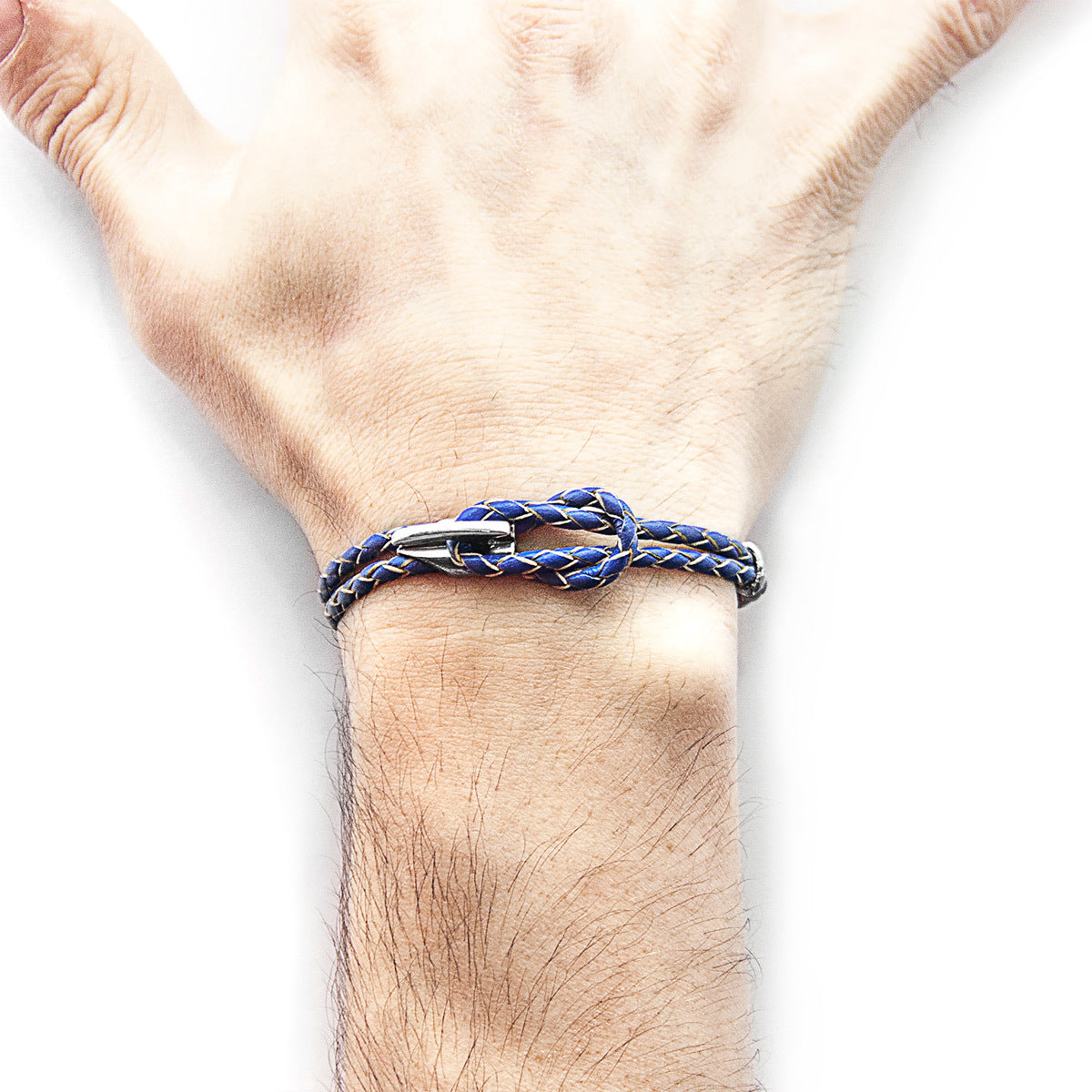 Bracelet with blue and silver design on a wrist against a white background