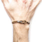 Brown braided bracelet on a wrist against a white background