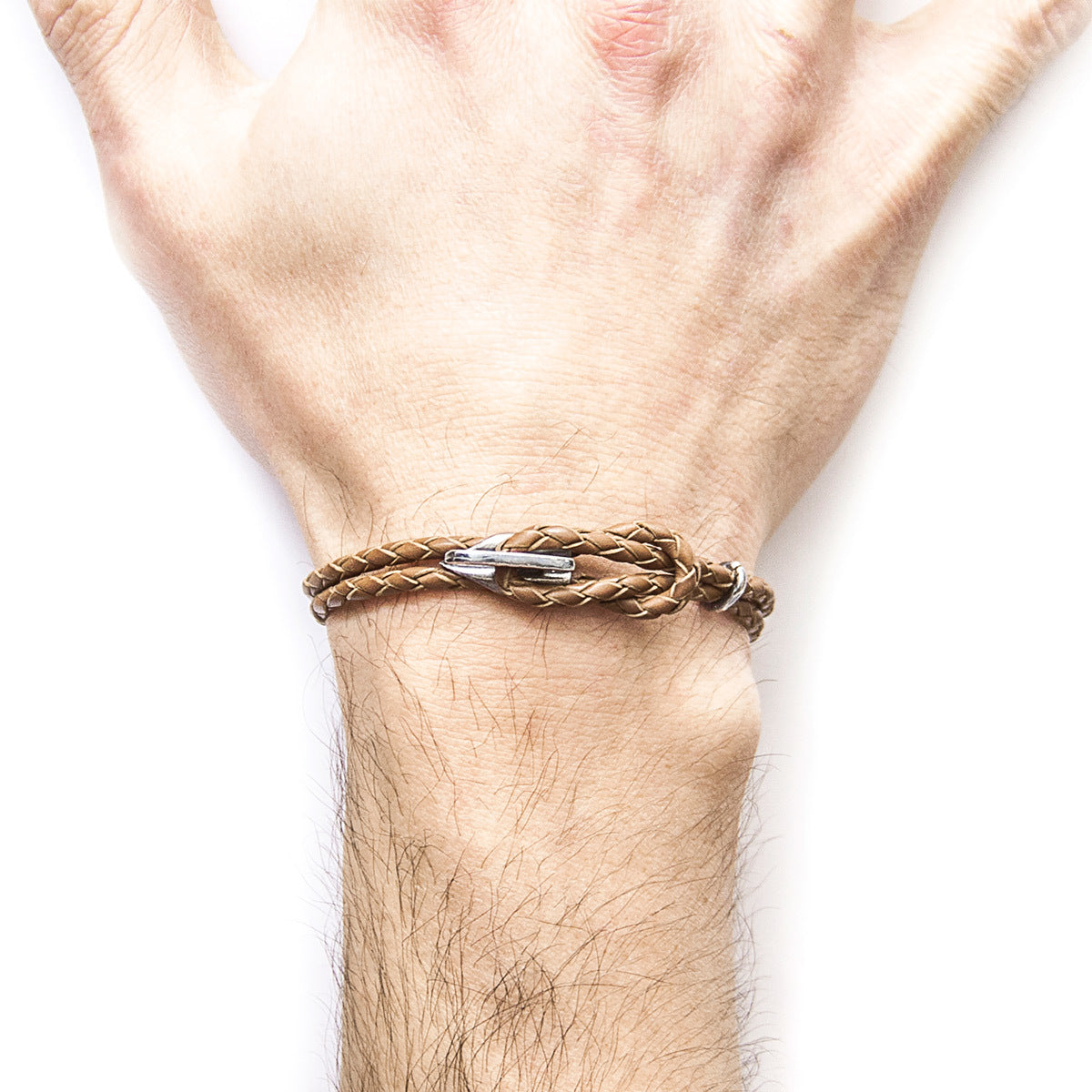 Brown braided bracelet on a wrist against a white background