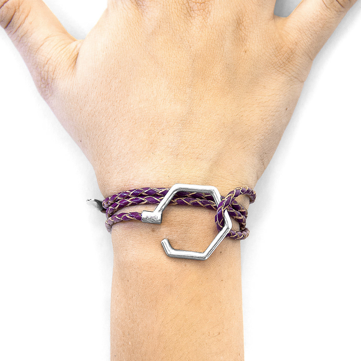 Purple braided bracelet with a silver hook charm on a wrist against a white background