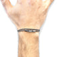 Hand wearing a silver bracelet on a white background