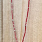 Beaded necklace with a leaf charm on a wooden surface