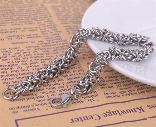 Silver chain bracelet on a textured surface with text