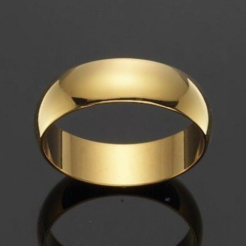 Gold ring on a reflective black surface with a dark background