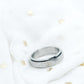 Silver ring with glittery band on a white background
