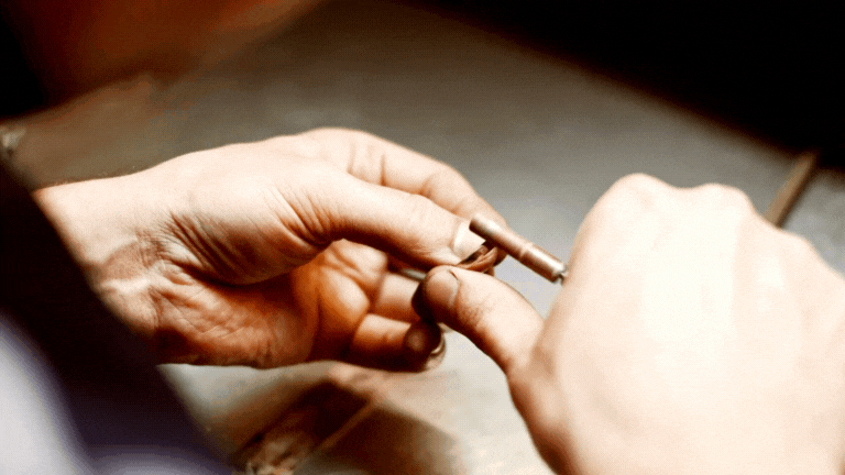 man making and polishing a gold ring