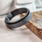 Black and silver ring on a textured surface