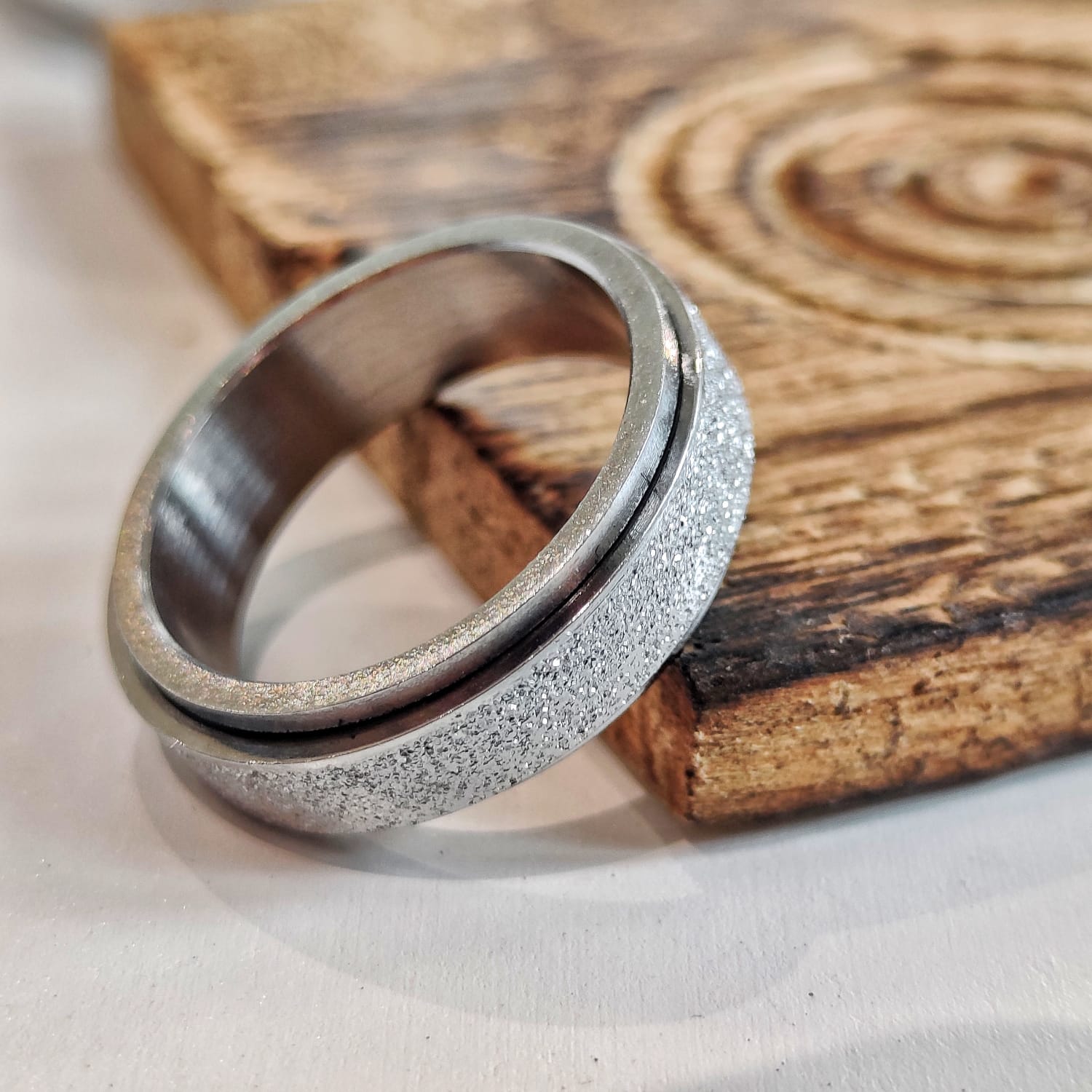 Two silver rings with textured surfaces on a wooden surface