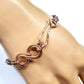 Rose gold chain bracelet on a mannequin hand against a white background