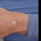 Silver snowflake bracelet on a wrist with a blue sleeve in the background