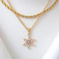 Gold necklace with a star-shaped pendant on a white background
