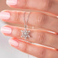 Silver snowflake necklace held between fingers against a neutral background