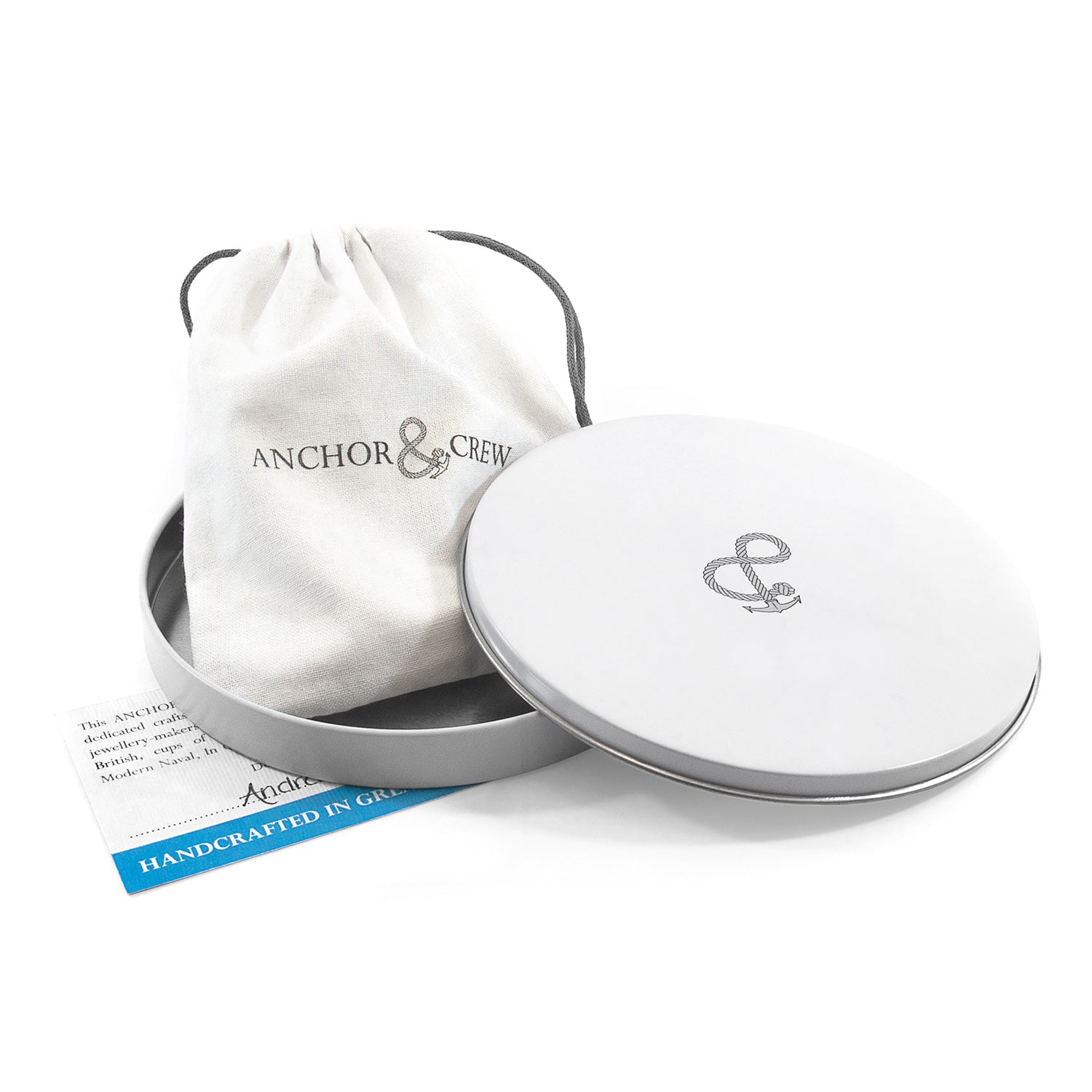 Silver jewelry box with 'Anchor & Crew' logo and branded drawstring bag on a white background