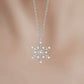 Silver snowflake pendant necklace on a blurred background