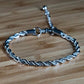 Silver braided bracelet on a wooden surface