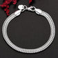 Silver bracelet on a dark background with red flowers