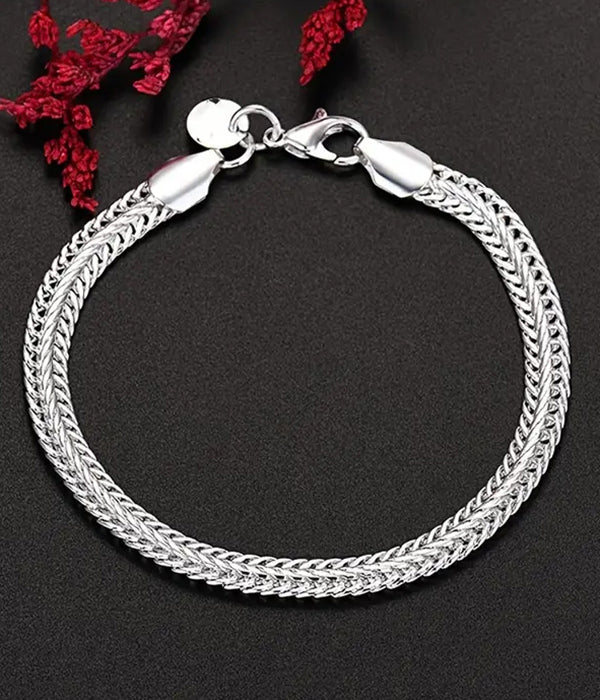 Silver bracelet on a dark background with red flowers