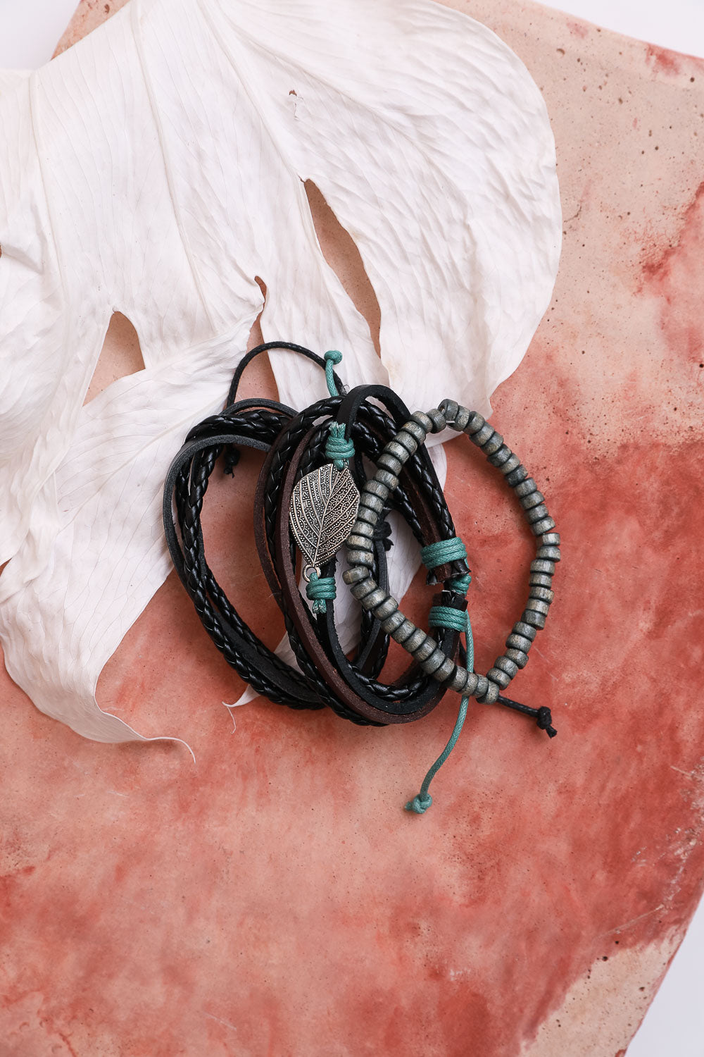 Set of braided bracelets with metal charm on a textured surface
